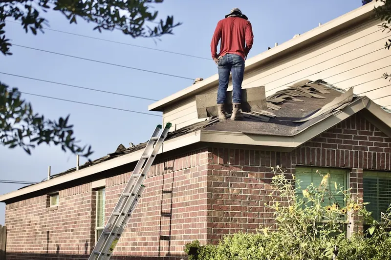 Professional roofer working on a residential roof in Winston